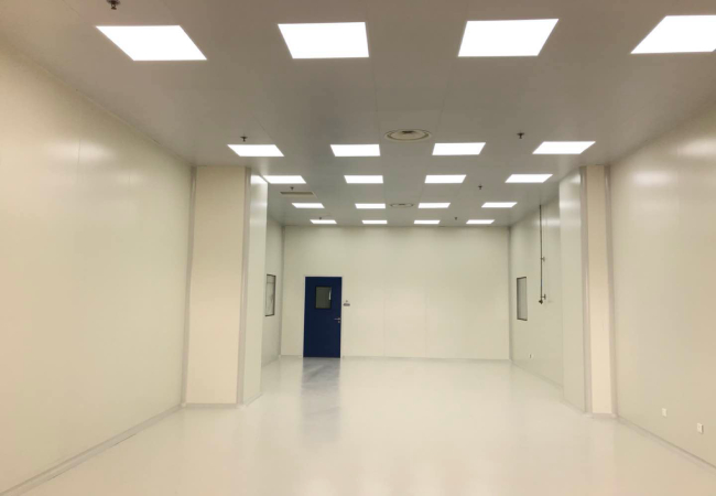Wonclean real project photo showing a long cleanroom room with continuous wall panels, ceiling lights and a cleanroom door